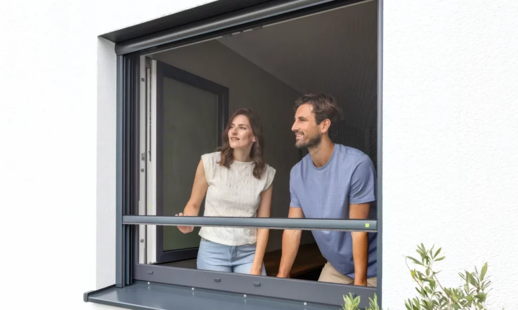 Mann und Frau vor einem Insektenschutzrollo