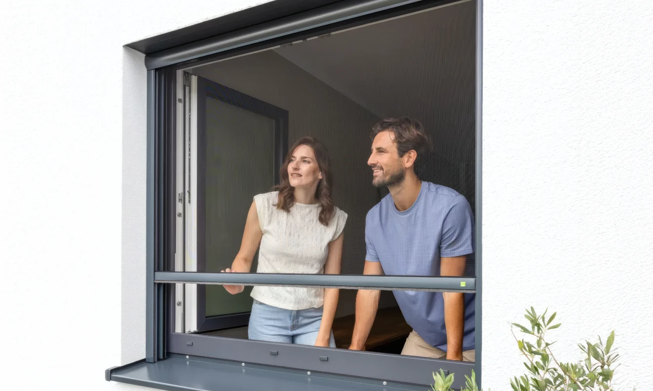 Mann und Frau vor einem Insektenschutzrollo