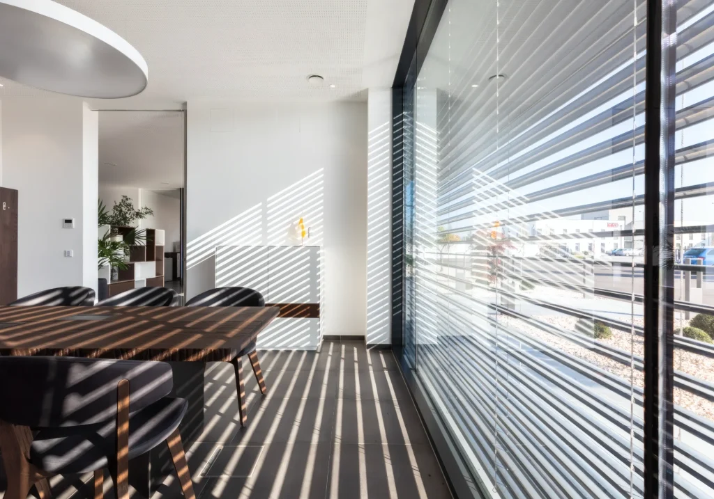 Modernes Wohnzimmer mit Raffstore-Sonnenschutz vor den Fenstern